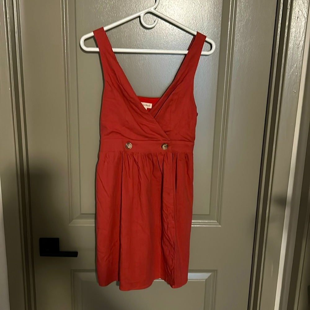 Red linen dress with front button closure.